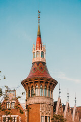 Fototapeta premium Detailed view of a decorative building spire featuring red and green tile patterns and stone carvings.
