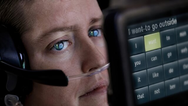 Disabled person using advanced eye tracking software to type message on screen.