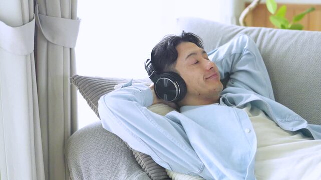 音楽を聴いてリラックスする男性のライフスタイルイメージ, Man Relaxing While Listening to Music at Home