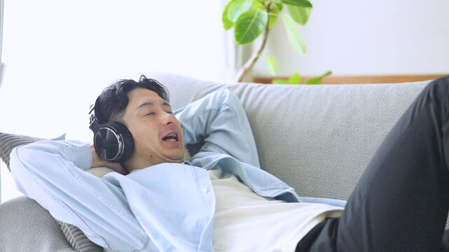 音楽を聴いてリラックスする男性のライフスタイルイメージ, Man Relaxing While Listening to Music at Home