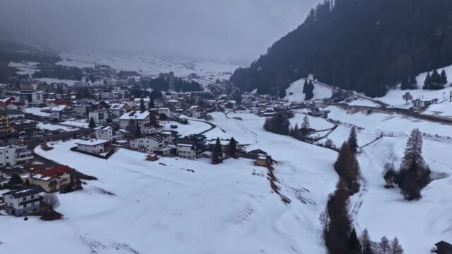 Snowy alpine village surrounded by ski slopes and conifer forest. Austria, Nauders