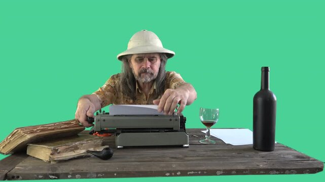 Thoughtful writer struggling with inspiration while typing, reviewing and crumpling paper beside vintage typewriter, wine glass and antique books on green screen background