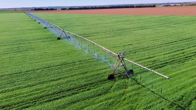 Aerial close view of center pivot irrigation system watering green field in Castilla La Mancha, rotating sprinklers and sustainable agriculture concept