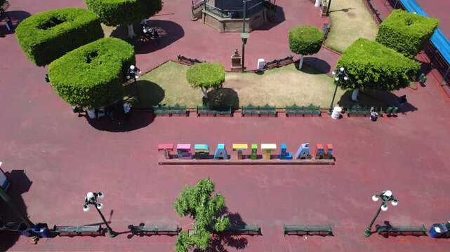 Toma a&eacute;rea ascendente desde las letras de Tepatitl&aacute;n revelando la plaza principal y la Parroquia de San Francisco de As&iacute;s, Jalisco, M&eacute;xico