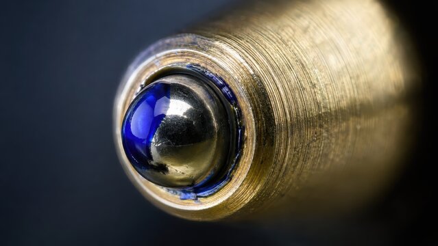 Extreme microscopic view revealing blue ink coating tiny metal ballpoint pen.