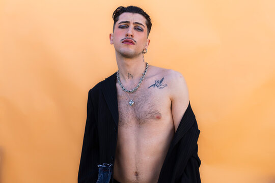 Young non binary person expressing individuality with makeup and fashion
