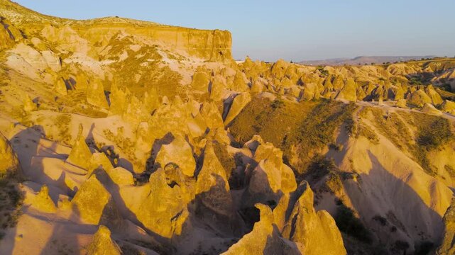 Goreme, Nevsehir, Turkey. Aerial view of Devrent Valley geological wonders showing wind erosion patterns and colorful rock strata at dusk.. Aerial View, Departure of the camera