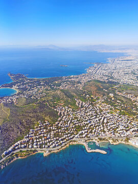 Aerial view of Glyfada, Piraeus and the Athens coastline &mdash; golden beaches, turquoise bays, bustling marina and white residences cascading toward the deep-blue Saronic Gulf, Greece.