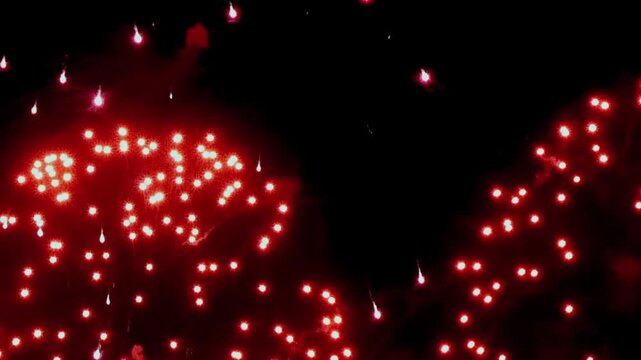Experience a mesmerizing array of sparkling red lights that dance across the night sky during an enchanting spring event. The atmosphere is filled with excitement and beauty as these lights twinkle.
