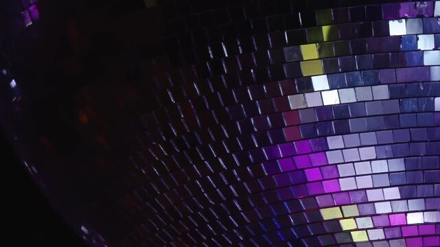 A magnificent disco ball shimmers with a kaleidoscope of vibrant red, blue, and purple lights, illuminating the celebratory atmosphere.