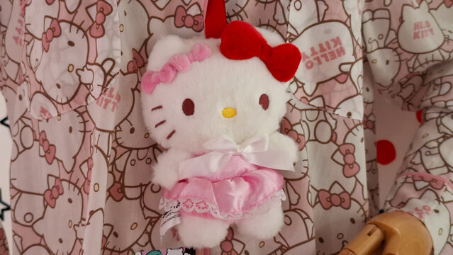 Adorable Hello Kitty plush doll wearing a cute dress on display with matching character pattern background on May 4, 2026 in Bangkok, Thailand