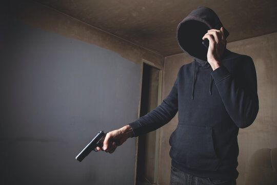Man with a gun in the dark room.