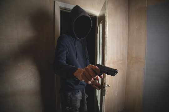 Man with a gun in the dark room.