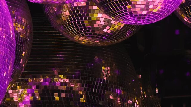 Experience a dazzling birthday night at the disco, where multiple shimmering balls cast vibrant purple, green, and golden reflections. A perfect atmosphere for celebrating and dancing all evening.