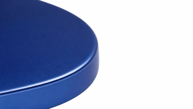Highlighting the thick smooth curved edge of a solid matte blue anodized aluminum headphone earcup outer shell entirely