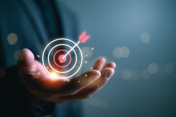 Businessman holding target icon with arrow hitting center, goal achievement, success strategy, performance focus, business planning, KPI growth and objective completion in modern corporate concept © Looker_Studio