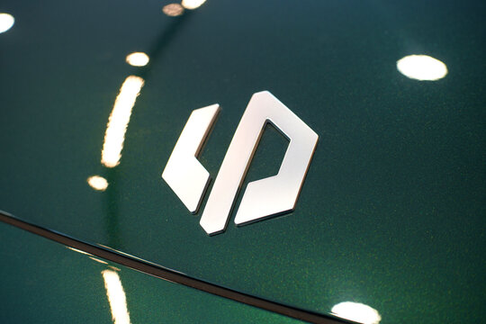 Penang, Malaysia - Apr 07, 2026: A detailed close-up of the silver Leapmotor brand logo on the dark green metallic hood of a C10+ electric SUV inside a showroom.
