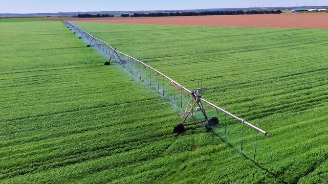 Aerial close view of center pivot irrigation system watering green field in Castilla La Mancha, rotating sprinklers and sustainable agriculture concept