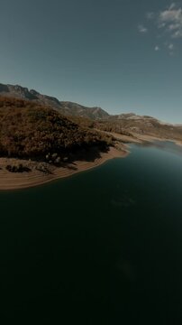 Cinematic vertical FPV drone footage flying over the calm waters and rugged shoreline of Porma Reservoir in Leon, Spain. Ideal for travel social media and nature documentaries.