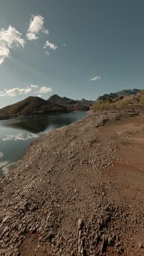 Cinematic vertical drone flight over the rocky shores and blue waters of Porma Reservoir in Spain. Perfect for social media travel content and environmental storytelling.