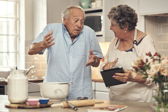 Confused, old couple and baking with tablet in kitchen for recipe doubt, tutorial error or uncertain. Senior people, cooking and shrug with tech in home for instructions mistake, clueless and support