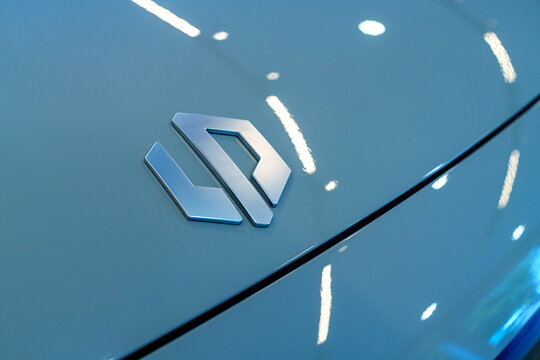 Penang, Malaysia - Apr 07, 2026: A detailed close-up of the silver Leapmotor brand logo on the blue hood of a B10 electric SUV inside a showroom.