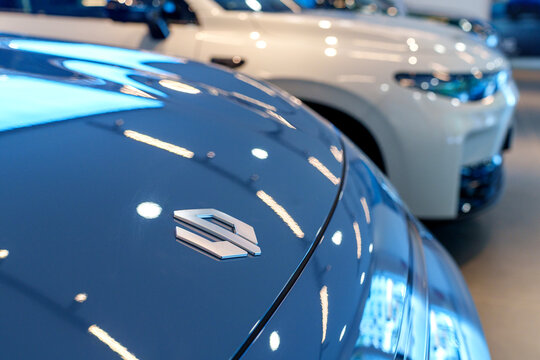 Penang, Malaysia - Apr 07, 2026: A close-up, shallow depth-of-field shot of the silver Leapmotor C10+ emblem on a blue metallic car hood, with other electric SUV models blurred in the background.