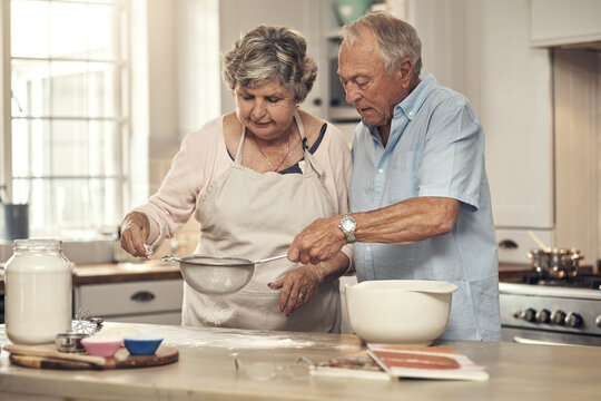 Help, old couple and baking with flour in kitchen for cake recipe, retirement hobby and bonding. Senior people, cooking support and sieve in home for dessert preparation, assistance and relationship