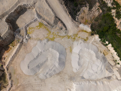 Aerial view of Marshalls Maltby quarry featuring large piles of white sand, excavated rock faces, and industrial dirt tracks in Maltby, England, United Kingdom.