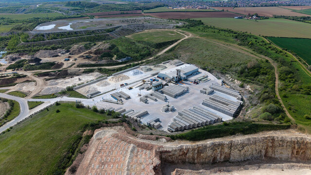 Aerial view of Marshalls Maltby industrial site with stacks of concrete blocks and a quarry pit under a clear sky Maltby, England, United Kingdom.