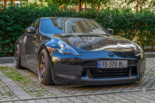 Tbilisi, Georgia, 10.29.2025 Black Nissan 370Z Parked Among Greenery in a Residential Complex