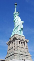 Fototapeta premium Close-up view of the Statue of Liberty with detailed pedestal and blue sky