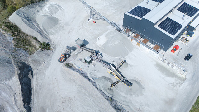 Aerial view of Foamed Glass Industrial Factory with conveyor belts, heavy machinery, and solar panels on the roof in Great Heck, England, United Kingdom.