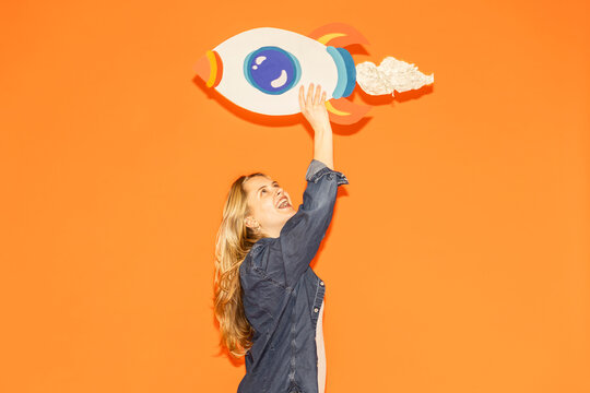 Woman holding a handmade paper rocket symbolizing growth and success