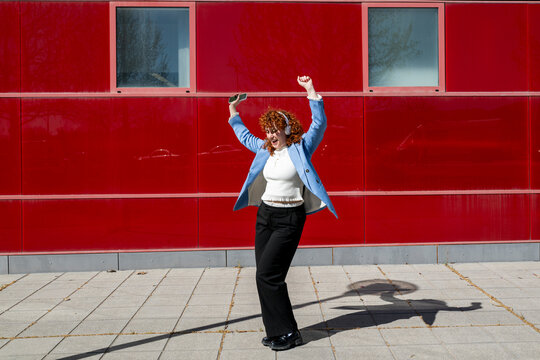 Entrepreneur in blue blazer dancing outdoors to music in Granada