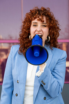 Entrepreneur shouting into a blue megaphone outdoors in Granada