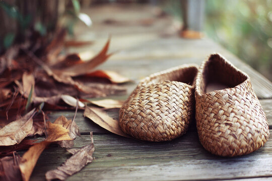 Eco friendly boutique hotel rustic woven slipper autumn leaf wooden floor natural texture cozy sustainable accommodation serene atmosphere