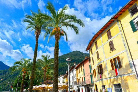 Farbenfrohe H&auml;userzeile mit Palmen an der Promenade von Riva di Solto am Iseosee, Italien