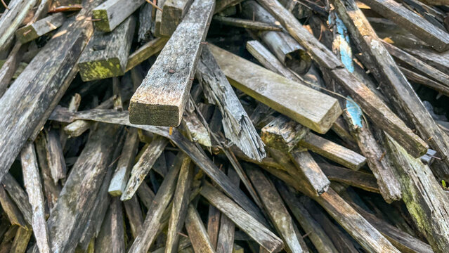 Pile of Old Weathered Wood Planks and Scrap Timber with Rusty Nails
