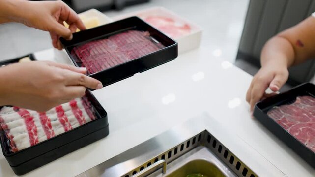 Diners Arranging Sliced Raw Beef Trays for Shabu Shabu Hot Pot