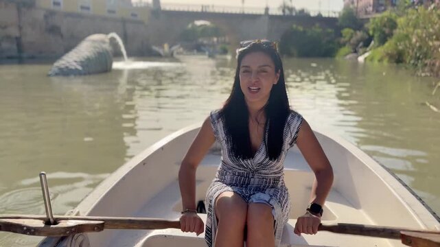 Latin woman paddling canoe on Segura River in Murcia, Spain, smiling and enjoying summer afternoon, travel lifestyle and freedom concept