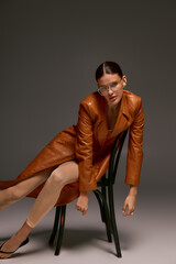 Stylish young woman poses confidently in leather coat with fashionable flair