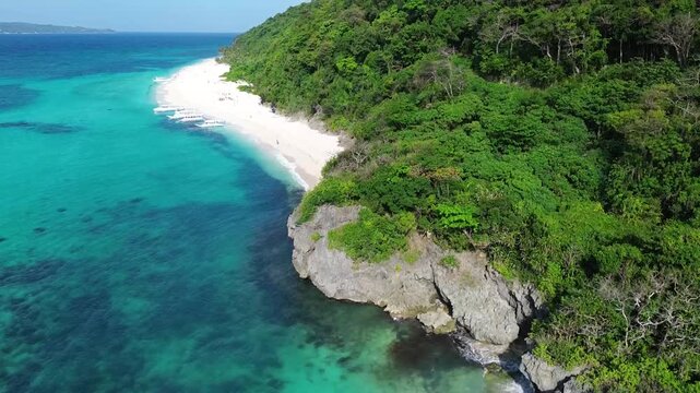 Drone view of tropical Puka Beach on Boracay island with blue ocean, white sandy shore and natural coastline landscape in the Philippines.