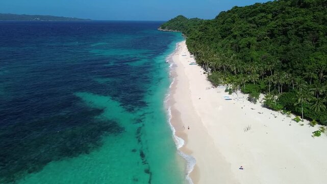 Drone view of tropical Puka Beach on Boracay island with blue ocean, white sandy shore and natural coastline landscape in the Philippines.