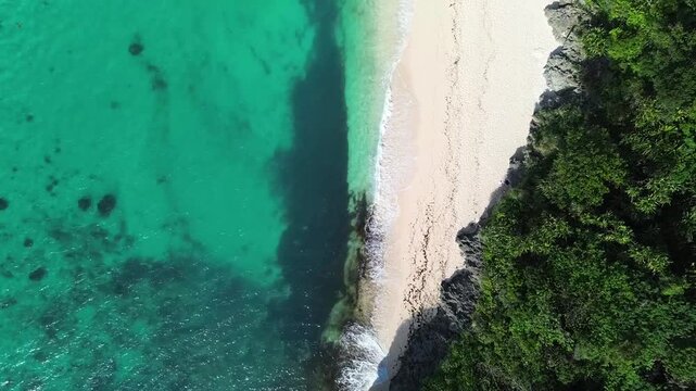 Drone view of tropical Puka Beach on Boracay island with blue ocean, white sandy shore and natural coastline landscape in the Philippines.