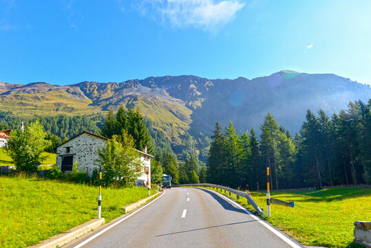 Berninapassstrasse mit Alph&uuml;tten vor imposanter Bergkulisse im Val Poschiavo Graub&uuml;nden, Schweiz