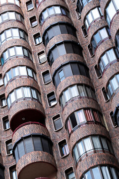 Rounded brick balcony geometry and abstract pattern on urban apartment building facade architecture in spain with modern residential exterior detail