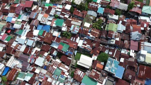 Aerial drone view over crowded urban settlement in Cebu Philippines with tightly packed residential buildings and rooftops.