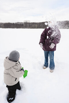 Family playing and throwing snow outdoors in winter