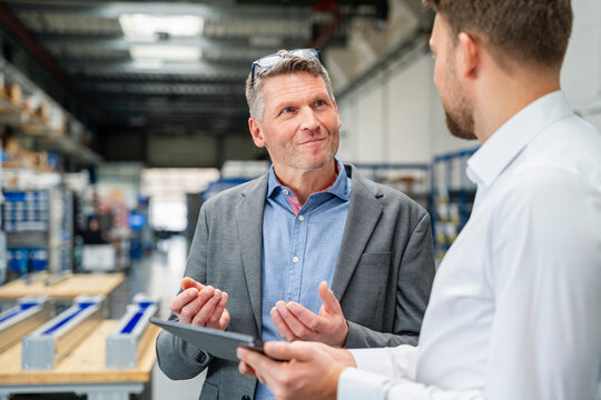 Supervisor and engineer discussing business in production hall